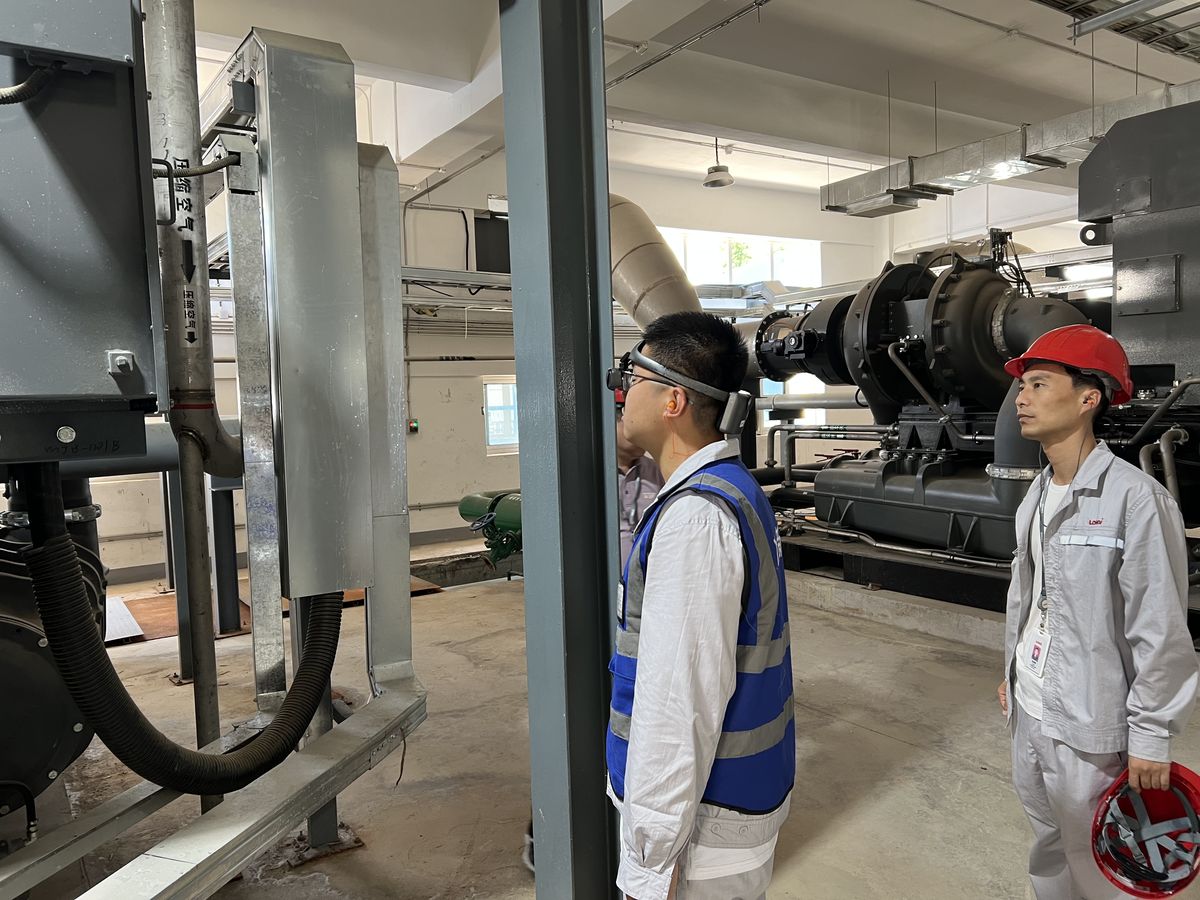 工业厂房内,工程师佩戴AR眼镜与同事一起巡检大型设备和管道